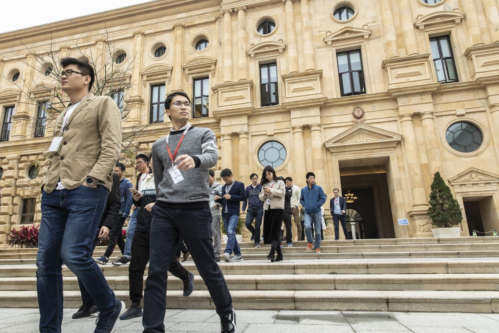  Сотрудники Huawei выходят из здания во время обеденного перерыва. В настоящее время в кампусе проживает 17 000 человек 