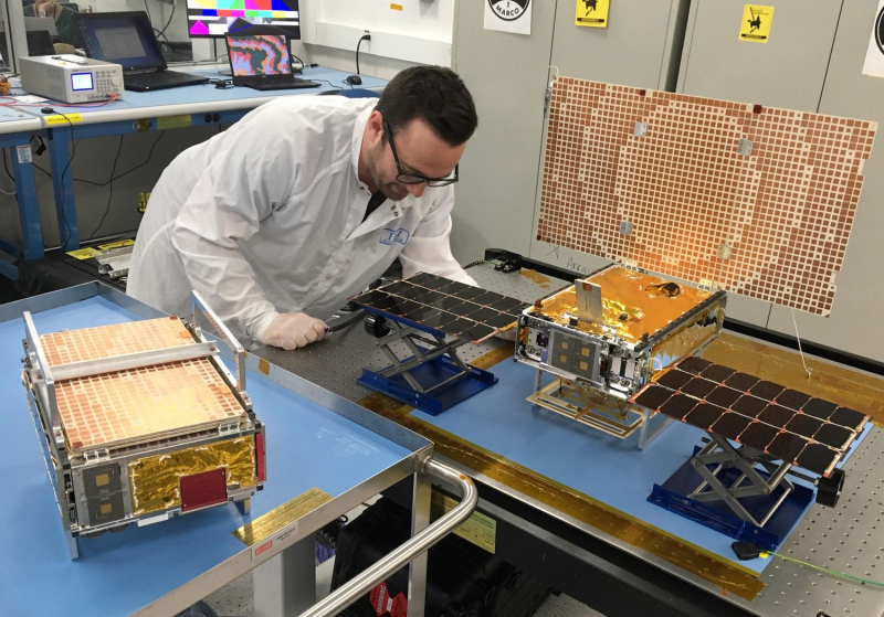  Инженер JPL демонстрирует космические аппараты MarCO: левый в транспортном положении, правый – в рабочем, с раскрытыми батареями и антенной. Источник: https://www.jpl.nasa.gov/images/pia22319-both-marco-spacecraft 