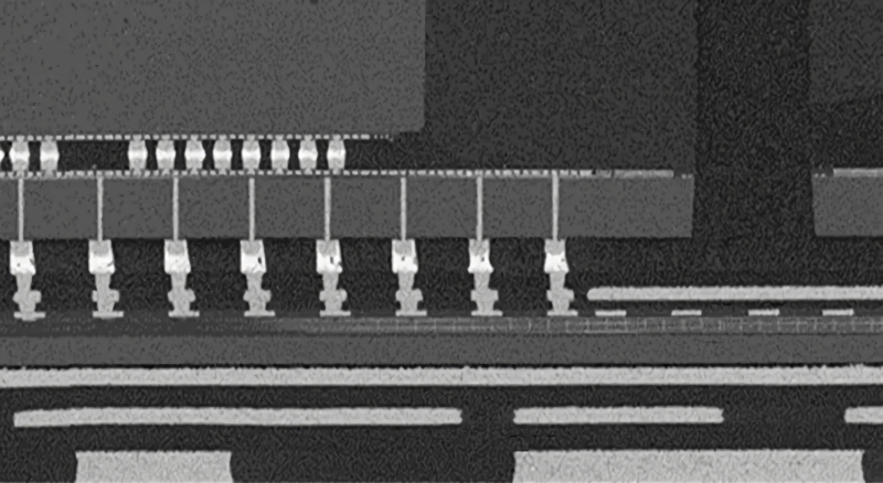  Сравнительные размеры микрозерни (короткие толстенькие столбики в верхней левой четверти снимка) и пилонов TSV (тонкие вертикальные линии в центральном поясе) в чипе архитектуры Ponte Vecchio. Горизонтальная светлая полоса правее ряда TSV — кремниевый мост, соединяющей данный базовый чиплет с соседним (источник: Intel) 