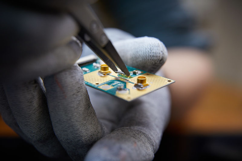  Учёный держит квантовый чип пинцетом, перед установкой на плату. Источник изображения: QuTech 
