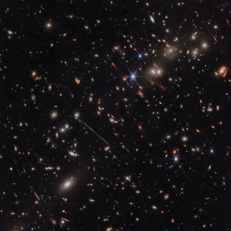  На изображении с камеры NIRCam видны сотни галактик, некоторые из которых никогда раньше не наблюдались в таких деталях. Скопление Толстяка действует как гравитационная линза, искажая и увеличивая свет от далеких фоновых галактик. 
