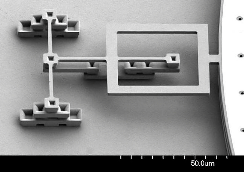  Поворотная MEMS-петля, изменение натяжения пружин которой приводит к отклонению от горизонтальной плоскости микрозеркала, — его краешек виден справа (источник: Bacteria-World) 